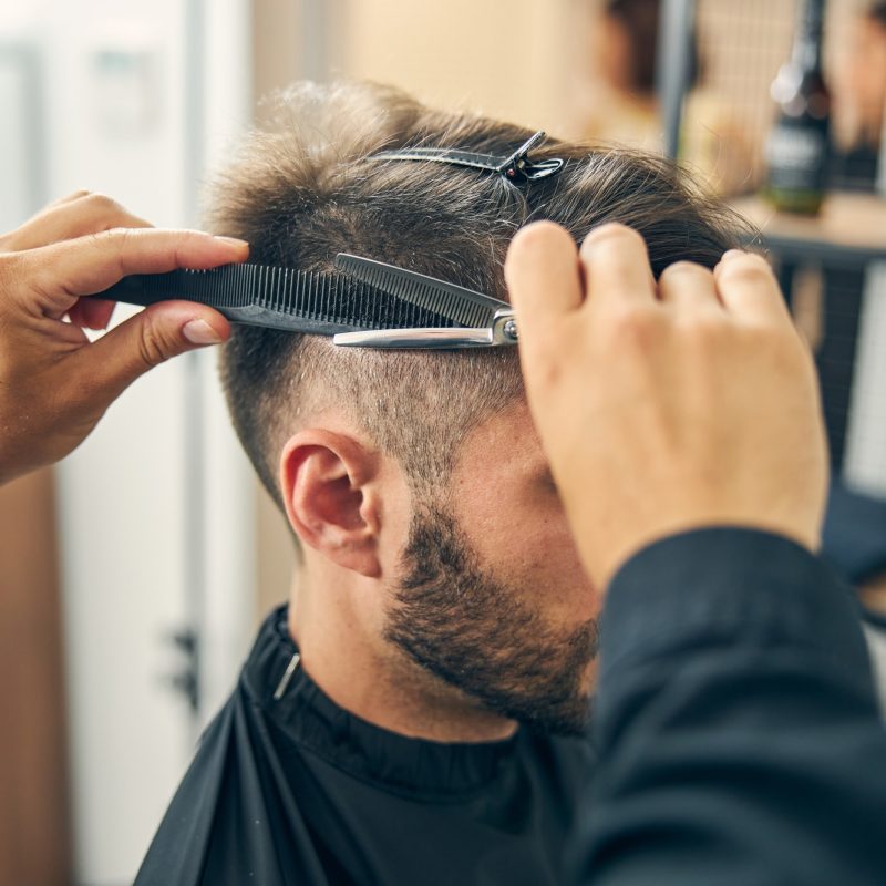 Close up of barber cutting hair in barbershop